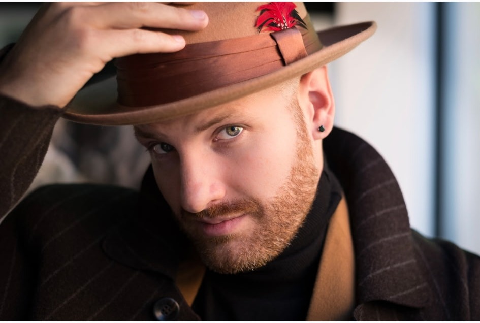 Brown pinstripe overcoat with a feathered felt hat